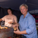 Melanie Witte-Lonsing hilft an einem Grillstand und bereitet ein Wurstbrötchen vor.